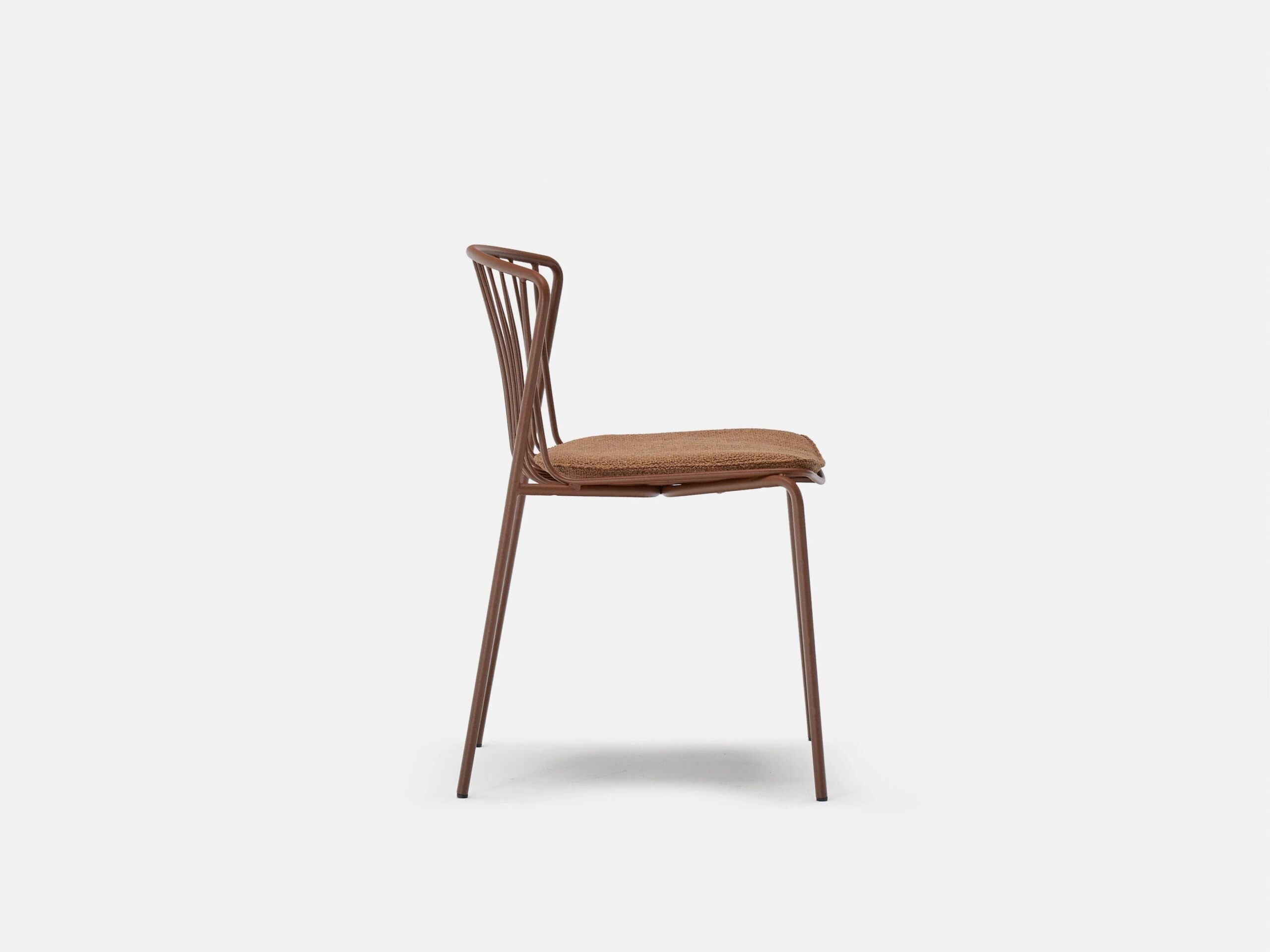 Side view of a minimalist brown metal chair with a woven seat cushion, set against a plain white background. The chair features a simple, modern design with slim legs and a slatted backrest.