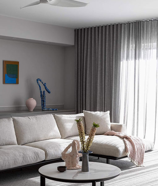 A stylish living room showcasing a Kett Indoor Sofa, a coffee table, and a ceiling fan, enhancing the space's comfort.