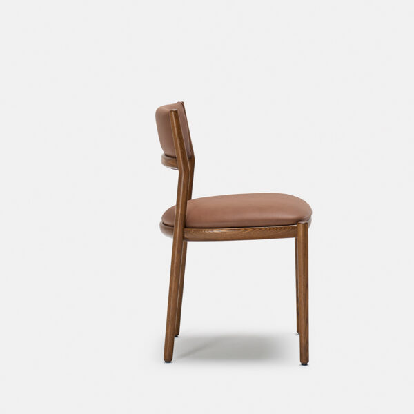 A wooden chair with light brown leather upholstery on the seat and backrest, shown from the side against a plain white background.