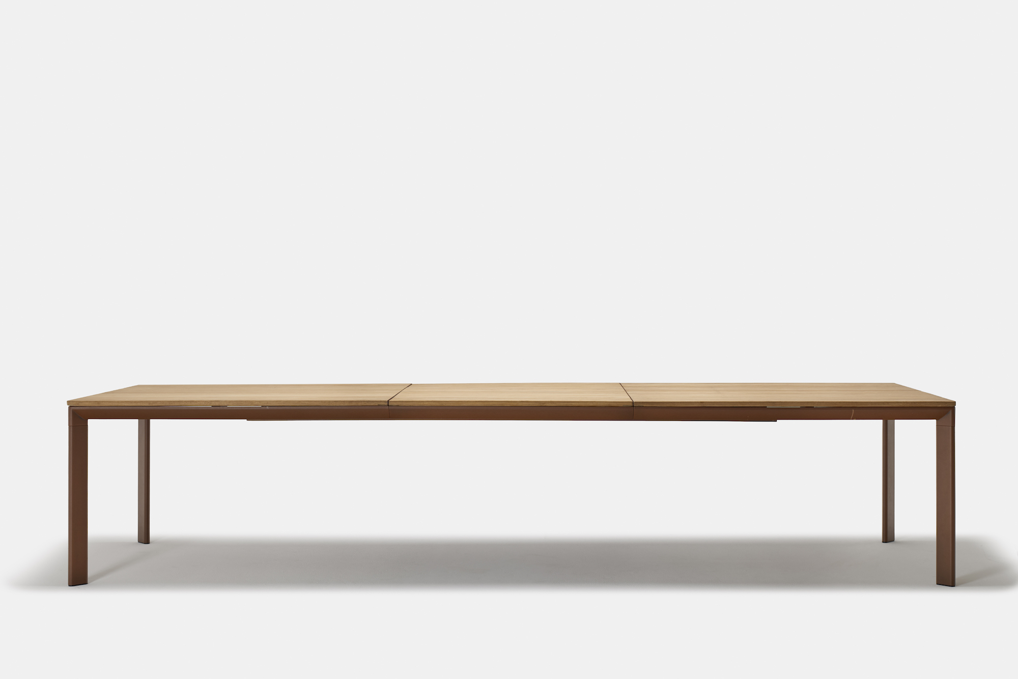 A rectangular wooden dining table with clean, minimalist lines and a smooth surface, set against a plain white background.