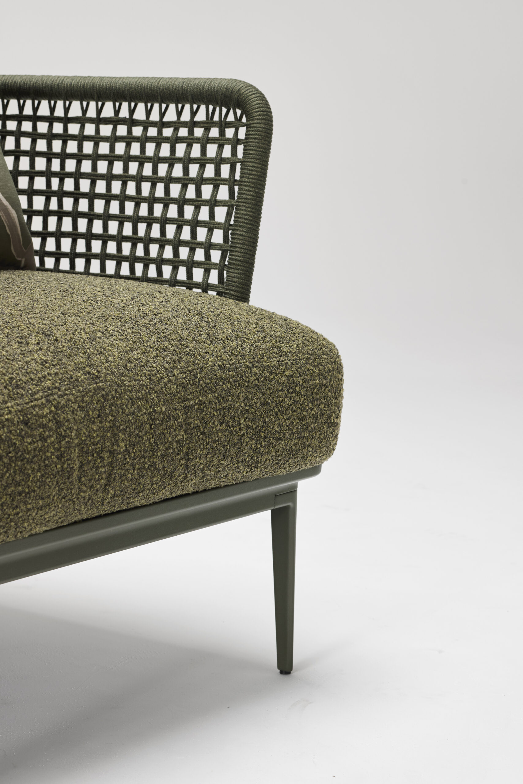 Close-up of a modern olive-green chair with textured fabric seat, woven backrest, and slender metal legs on a plain white background.