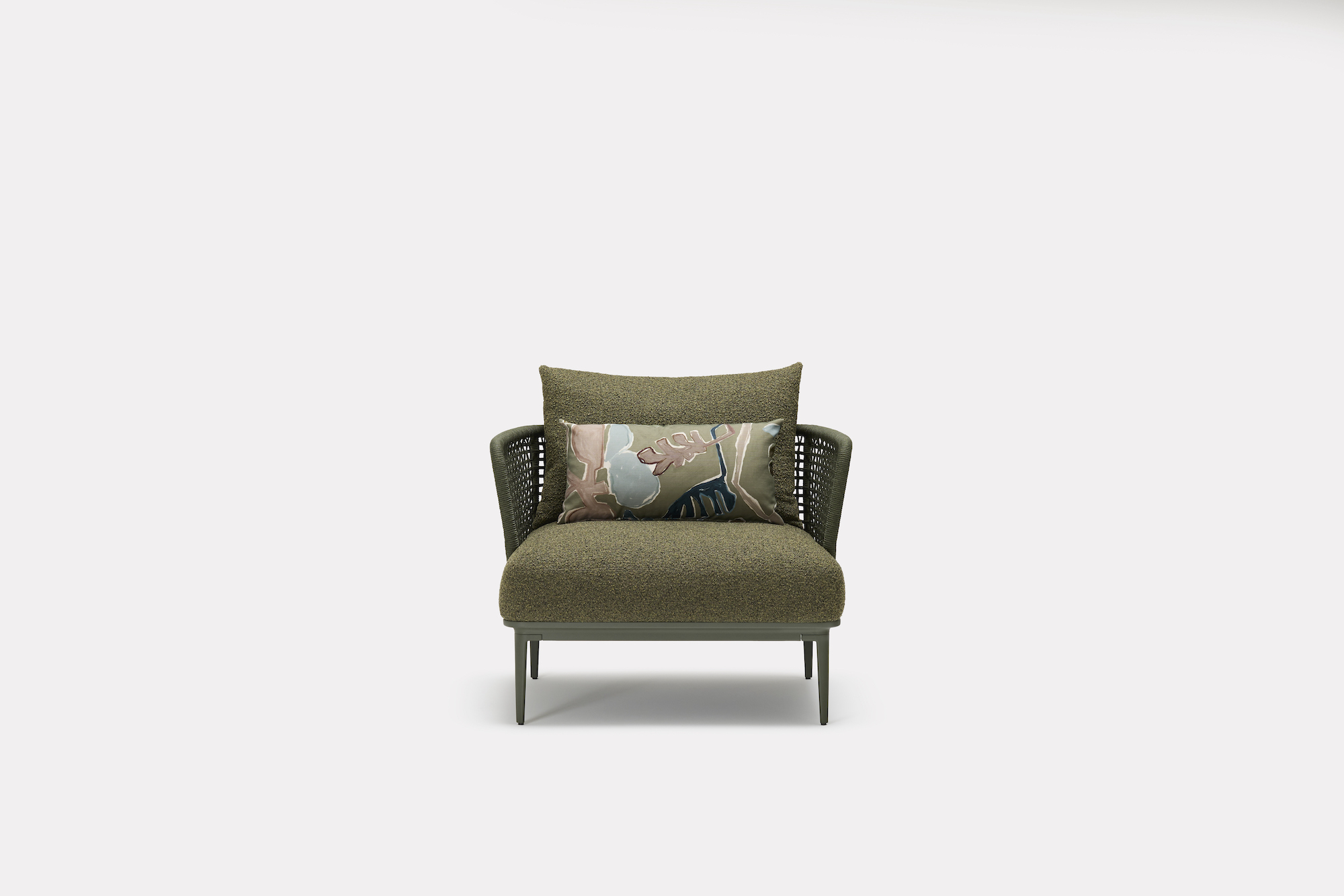 A modern green armchair with woven sides, an olive green seat cushion, a matching back cushion, and a decorative pillow featuring pastel abstract patterns, set against a plain white background.