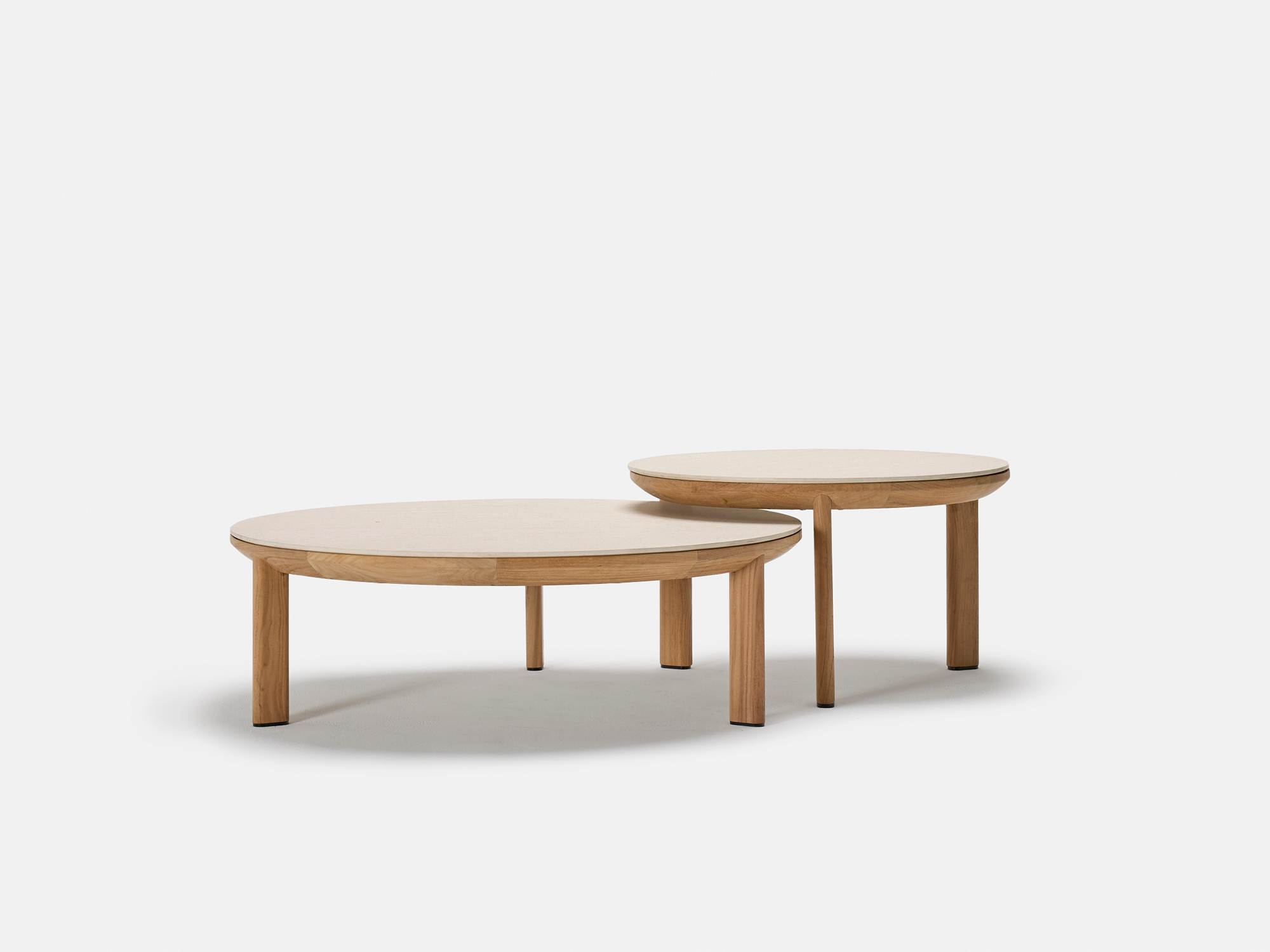 Two round wooden tables of different heights and sizes are placed side by side on a plain white background. The tables have simple, minimalist designs with smooth surfaces and straight legs.